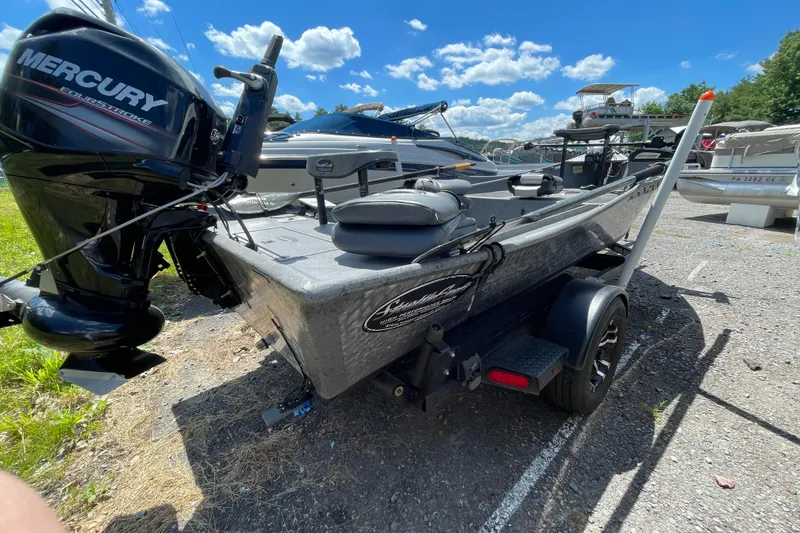 Slide: The Image of 2018 StealthCraft 16 Power Drifter boat with Mercury engine, parked outdoors under blue sky. - 9