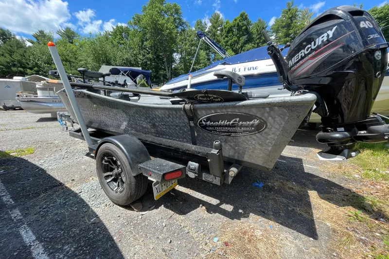 Slide: The Image of 2018 StealthCraft 16 Power Drifter boat with Mercury engine on trailer, parked outdoors. - 6