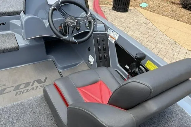 Slide: The Image of 2025 Falcon Boats F-18 interior with steering wheel and red-accented seat. - 2