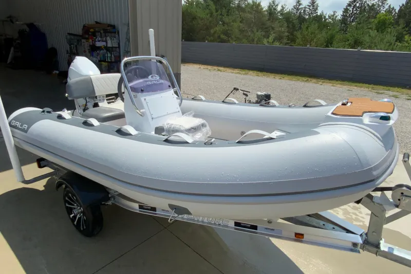 Slide: The Image of 2027 Gala A330L inflatable boat on trailer, parked outdoors near a garage. - 5