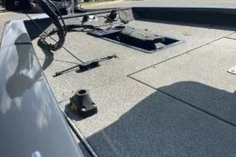 Slide: The Image of 2019 Tracker Pro Team 190 TX boat deck with storage compartments and fishing rod holders. - 7