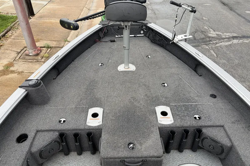 Slide: The Image of 2024 Lund 1875 Pro Guide boat interior with fishing rod holders and seating. - 6