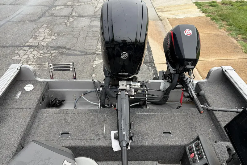 Slide: The Image of 2024 Lund 1875 Pro Guide boat with dual outboard motors on a paved surface. - 5