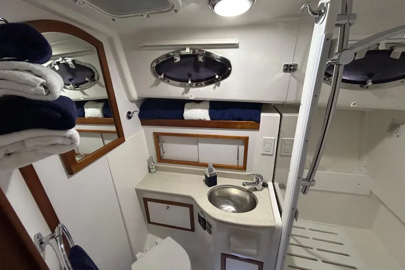 Slide: The Image of Luxurious bathroom in 2016 Back Cove 34 yacht with sink, mirror, and towels. - 53