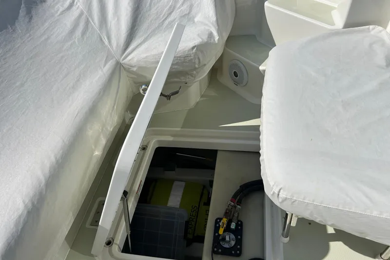 Slide: The Image of 2016 Back Cove 34 boat interior with open storage compartment and covered seating. - 18