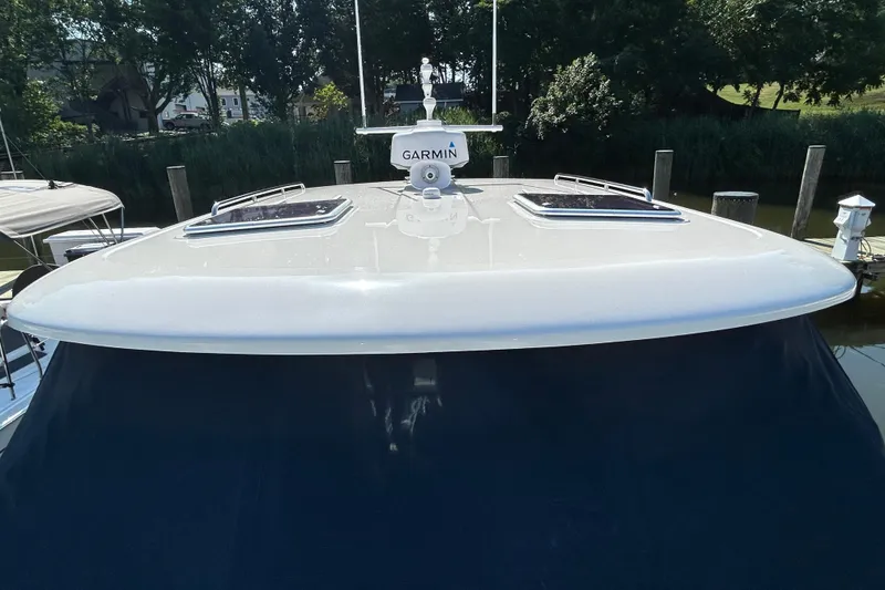 Slide: The Image of 2016 Back Cove 34 boat with Garmin equipment, docked near lush greenery. - 11