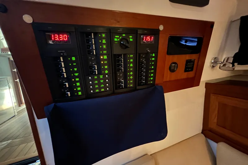 Slide: The Image of Electrical control panel on a 2016 Back Cove 34 boat, featuring illuminated switches and displays. - 50