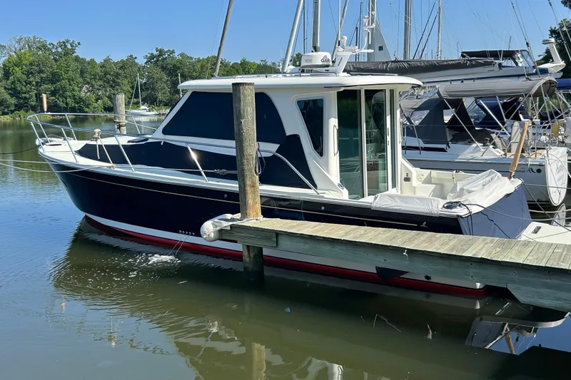 Slide: The Image of 2016 Back Cove 34 boat docked at marina, surrounded by sailboats. - 4