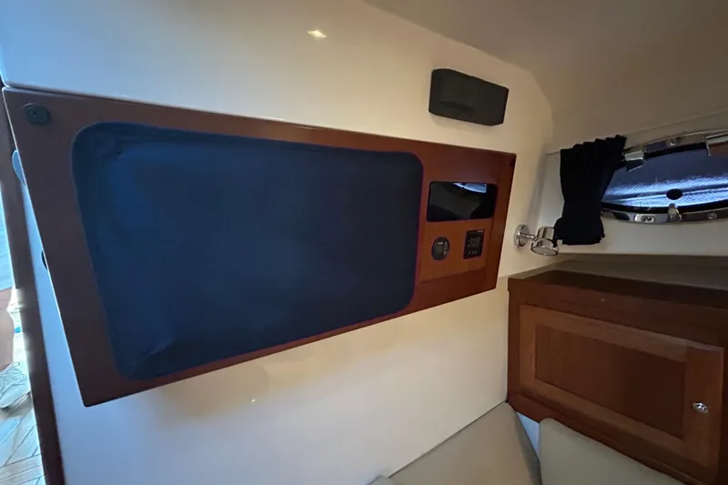 Slide: The Image of Interior of a 2016 Back Cove 34 boat, featuring a wooden panel and porthole. - 49
