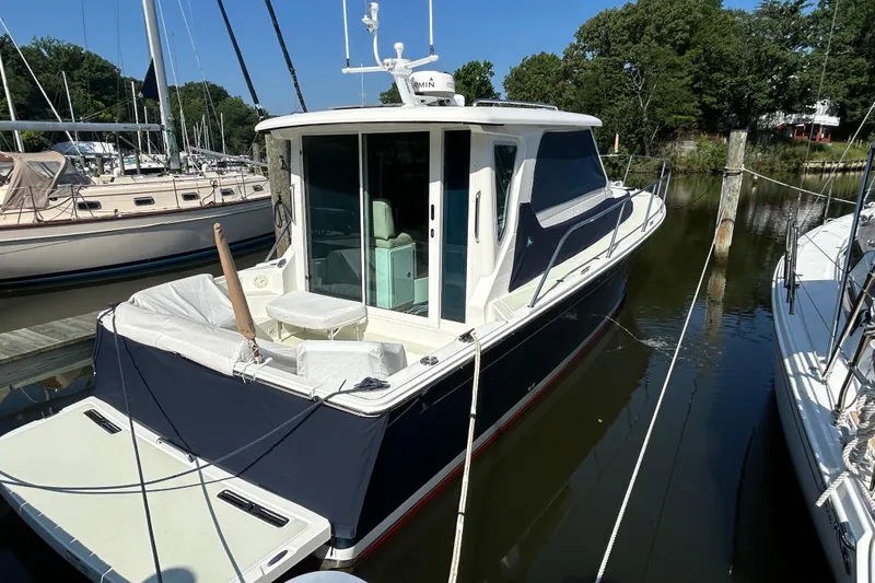 Slide: The Image of 2016 Back Cove 34 boat docked in a marina, surrounded by other vessels. - 7
