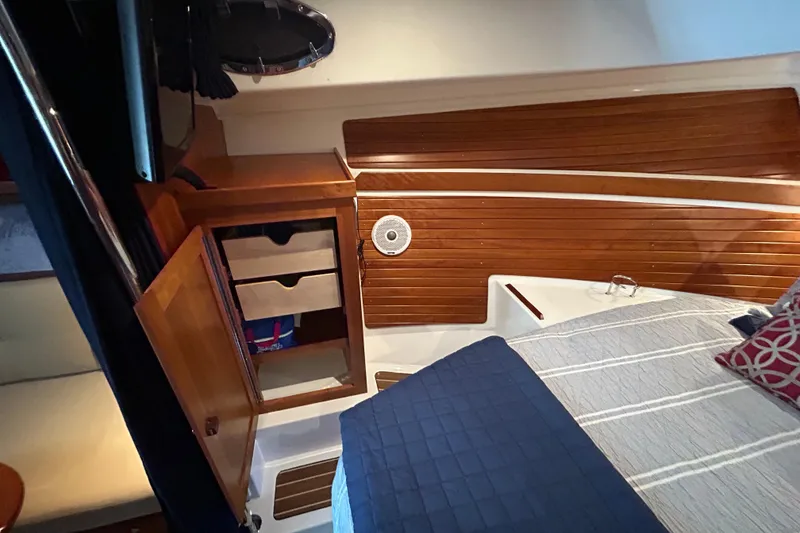 Slide: The Image of Interior of 2016 Back Cove 34 boat with wooden cabinetry and cozy bedding. - 58