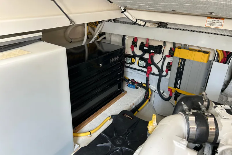 Slide: The Image of Engine room of a 2016 Back Cove 34 boat, featuring electrical components and storage. - 28