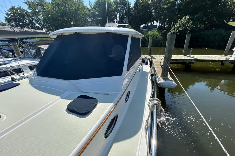 Slide: The Image of 2016 Back Cove 34 yacht docked, featuring sleek design and shaded windows. - 8