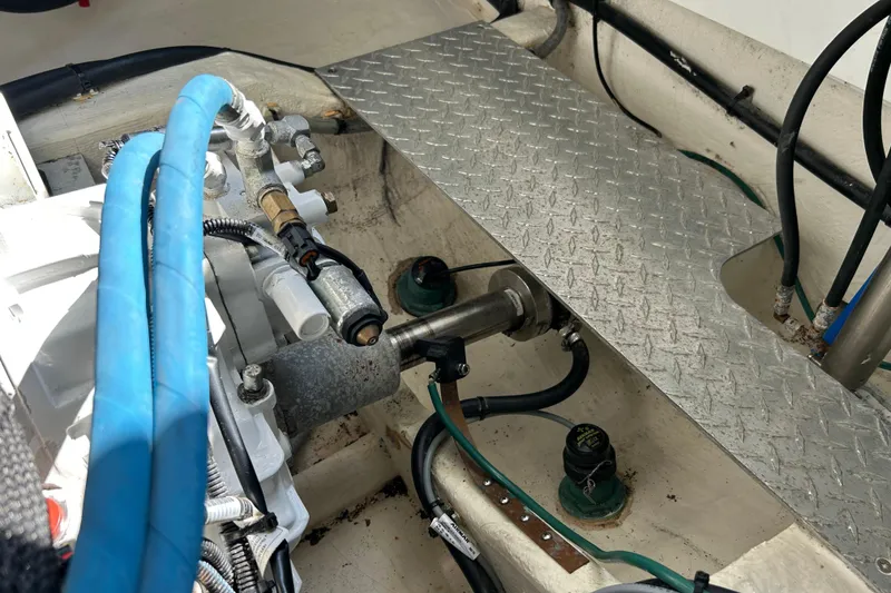 Slide: The Image of Engine compartment of a 2016 Back Cove 34 boat, featuring hoses and metal components. - 33