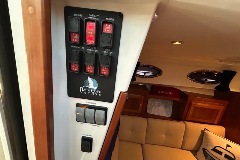 Slide: The Image of Control panel inside 2016 Back Cove 34 yacht, featuring switches for engine, thrusters, and lights. - 52