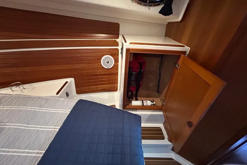 Slide: The Image of Interior cabin of a 2016 Back Cove 34 boat with wooden paneling and open storage. - 59