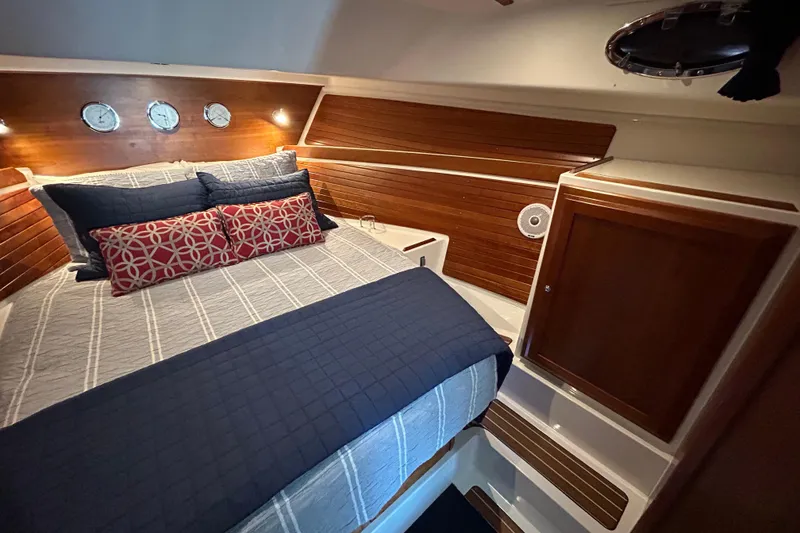 Slide: The Image of Cozy cabin interior of 2016 Back Cove 34 boat with elegant wood paneling and plush bedding. - 61
