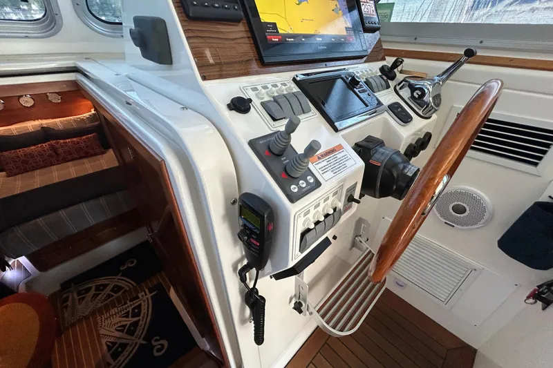 Slide: The Image of Helm of 2016 Back Cove 34 boat with navigation controls and wooden steering wheel. - 42