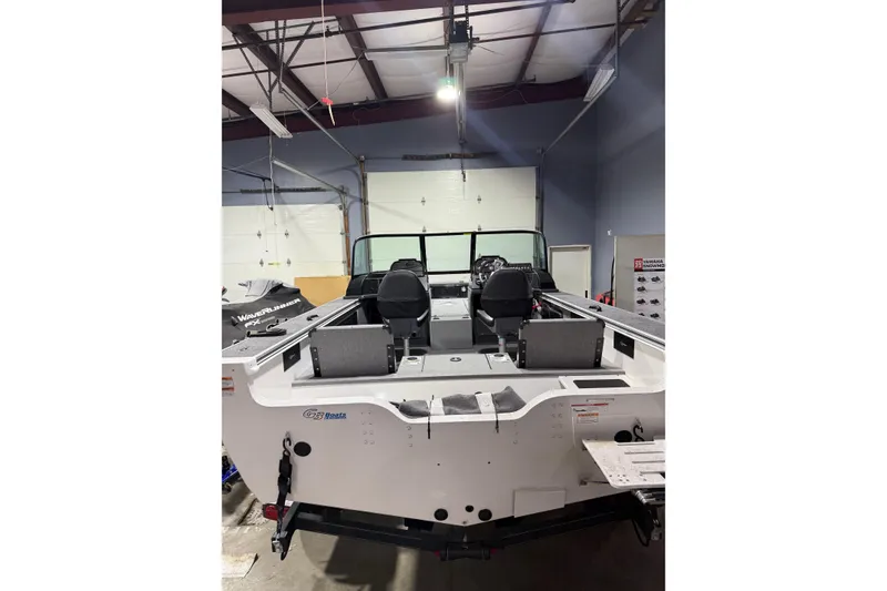 Slide: The Image of 2025 G3 Angler V1850 SF boat in a showroom, rear view with seating and controls visible. - 14