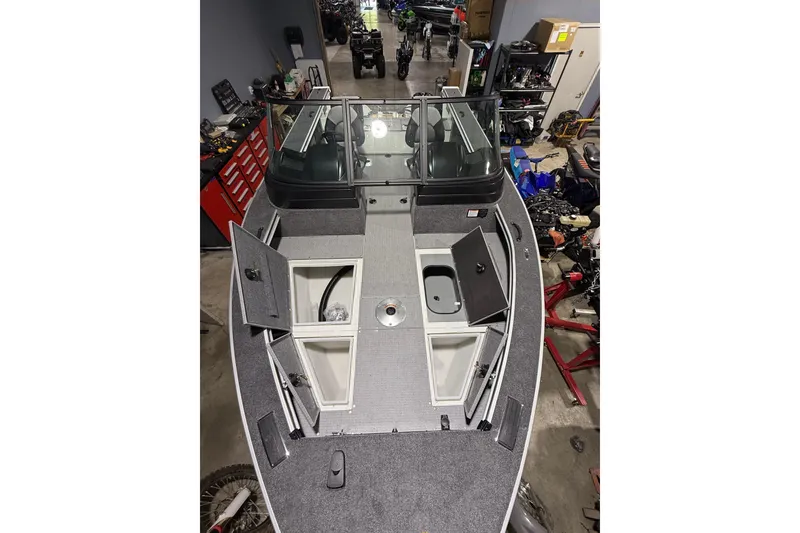 Slide: The Image of 2025 G3 Angler V1850 SF boat interior with open storage compartments in a workshop setting. - 3