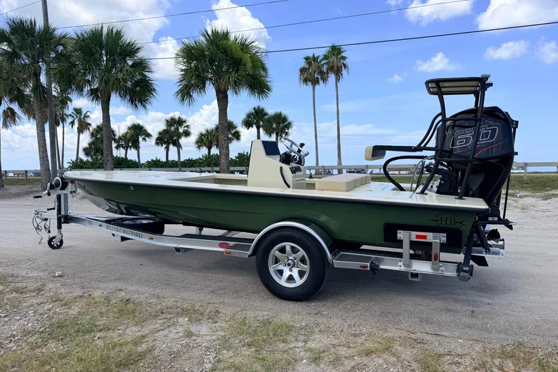 Slide: The Image of 2025 Hell's Bay Professional boat on trailer, parked near palm trees under a blue sky. - 7