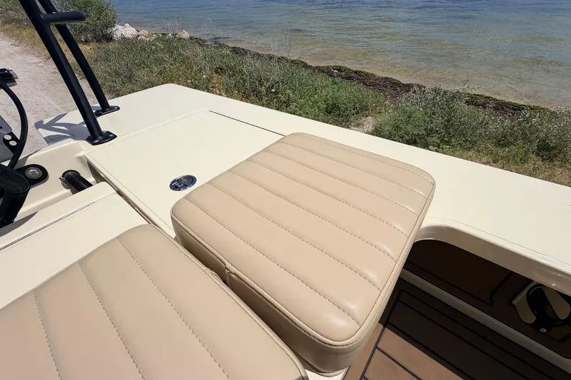 Slide: The Image of 2025 Hell's Bay Professional boat with beige seating, near a scenic shoreline. - 62