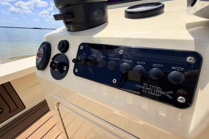 Slide: The Image of Control panel of a 2025 Hell's Bay Professional boat, featuring various switches and buttons. - 48