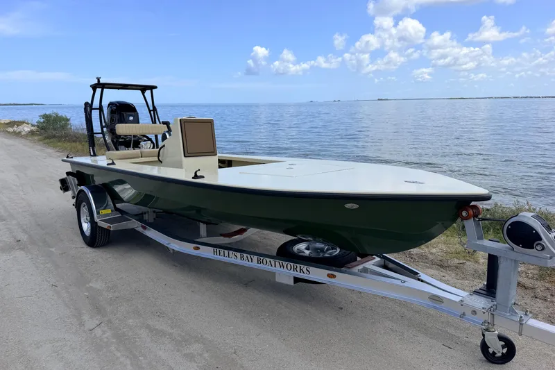 Slide: The Image of 2025 Hell's Bay Professional boat on trailer by the waterfront under a clear blue sky. - 3