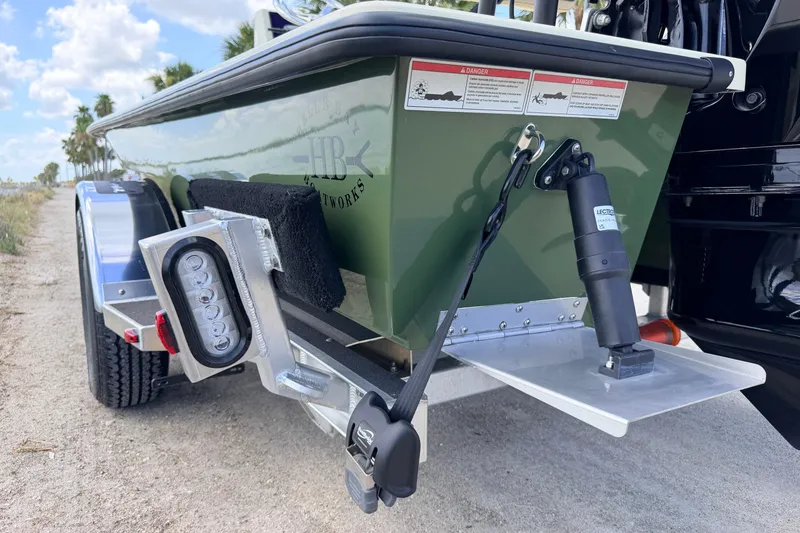 Slide: The Image of 2025 Hell's Bay Professional boat on trailer, featuring green hull and LED lights. - 15