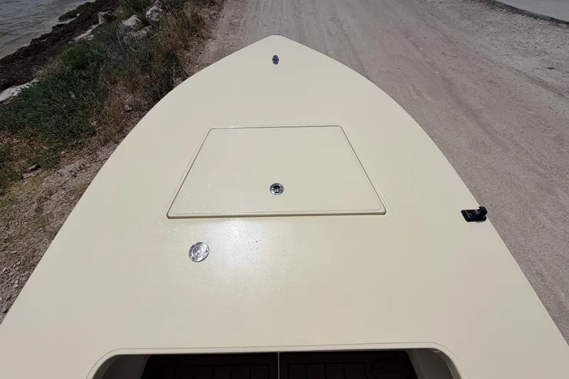 Slide: The Image of 2025 Hell's Bay Professional boat deck, beige color, near shoreline. - 31