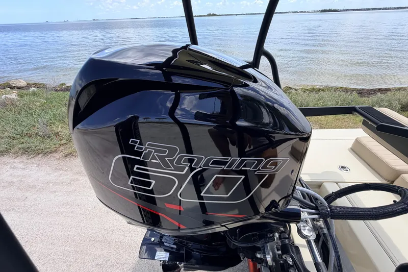 Slide: The Image of 2025 Hell's Bay Professional boat with a Racing 60 outboard motor by the water. - 70