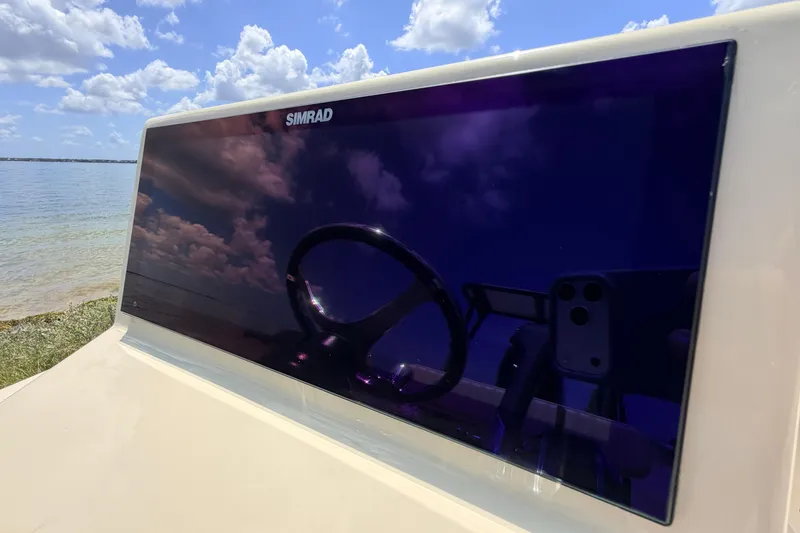 Slide: The Image of Reflection on Simrad display of Hell's Bay Professional 2025 boat, with scenic water view. - 46