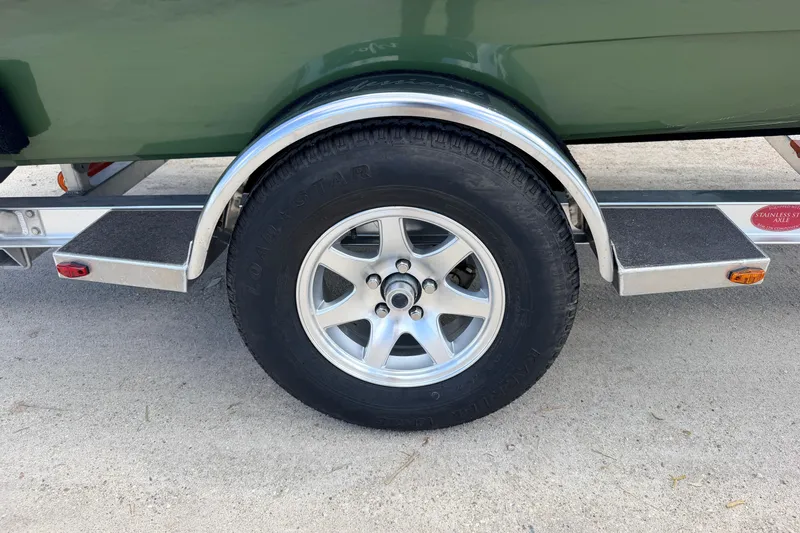 Slide: The Image of Trailer wheel of 2025 Hell's Bay Professional boat, featuring aluminum rim and Load Star tire. - 26