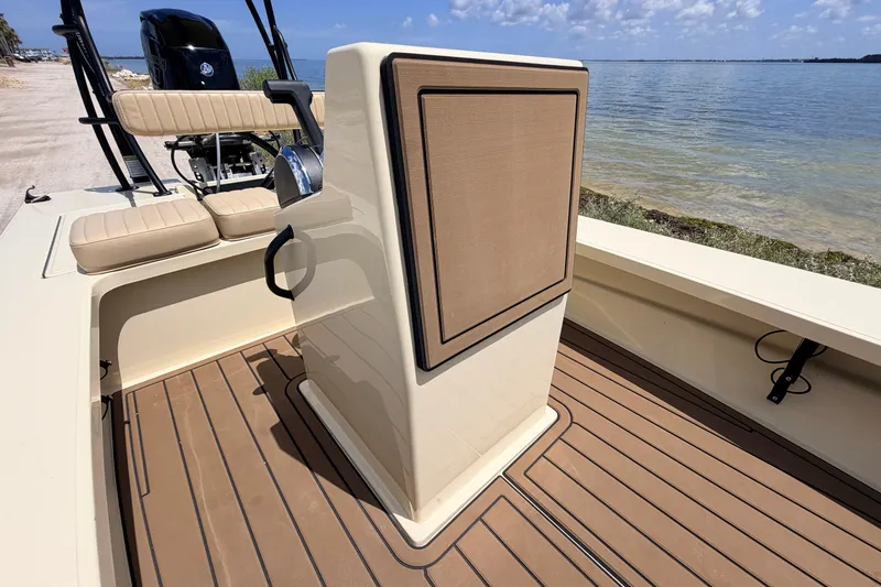 Slide: The Image of 2025 Hell's Bay Professional boat interior with tan seating and wood-style flooring by the water. - 41