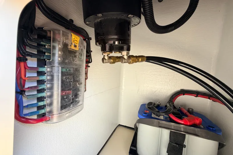 Slide: The Image of Electrical system components in a 2025 Hell's Bay Professional boat, featuring wiring and fuse box. - 53
