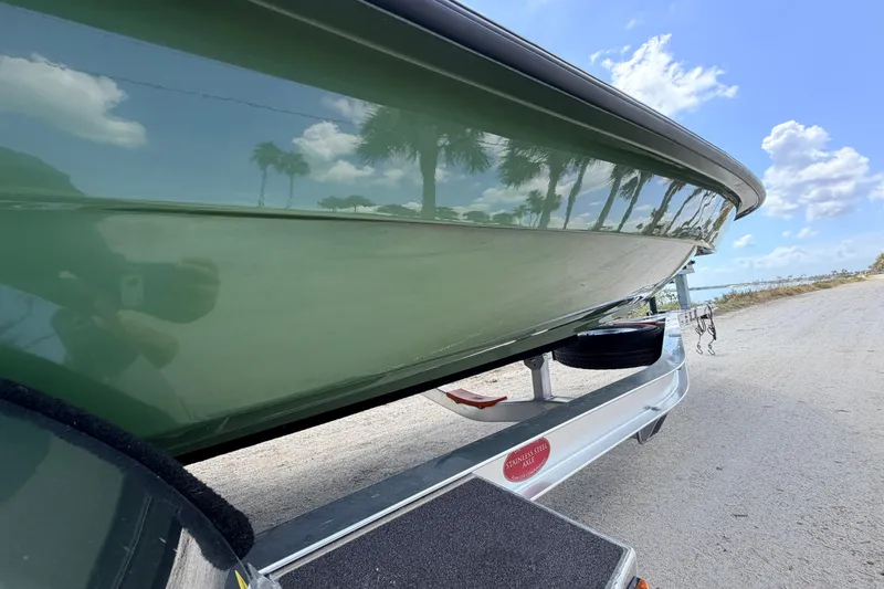 Slide: The Image of 2025 Hell's Bay Professional boat on trailer, reflecting palm trees under a blue sky. - 27