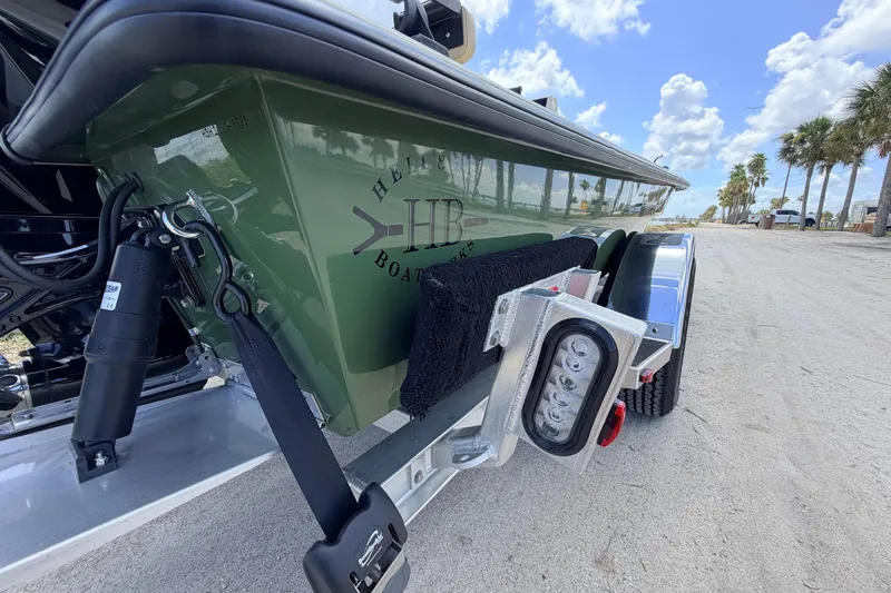 Slide: The Image of 2025 Hell's Bay Professional boat on trailer, parked on sandy road with palm trees. - 24
