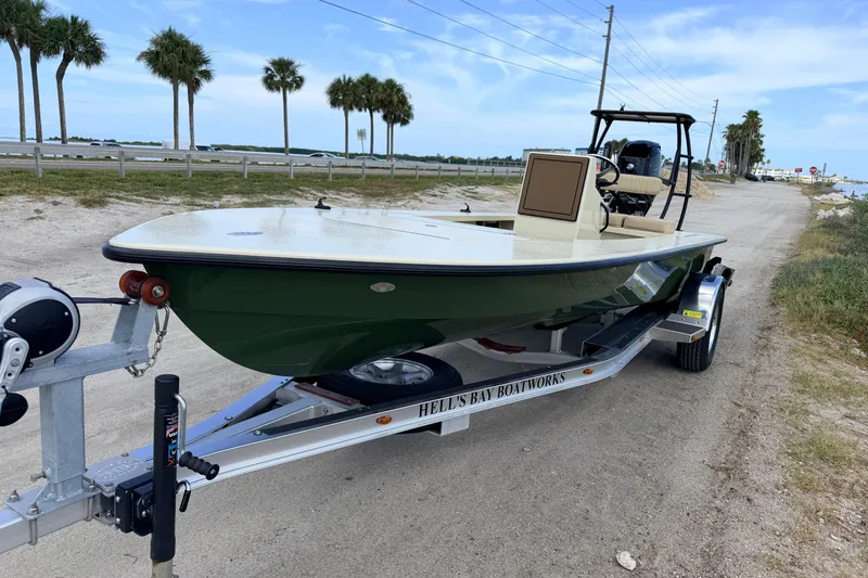Slide: The Image of 2025 Hell's Bay Professional boat on trailer, parked near a coastal road with palm trees. - 5
