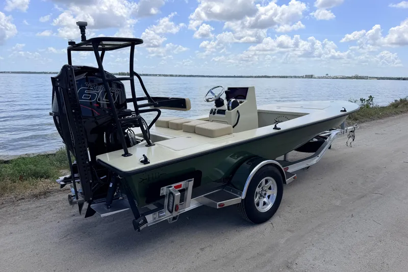 The Image of 2025 Hell's Bay Professional boat on trailer by the water, under a cloudy sky. - 1
