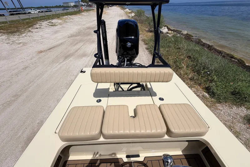 Slide: The Image of 2025 Hell's Bay Professional boat with beige seating, parked by a scenic shoreline. - 55