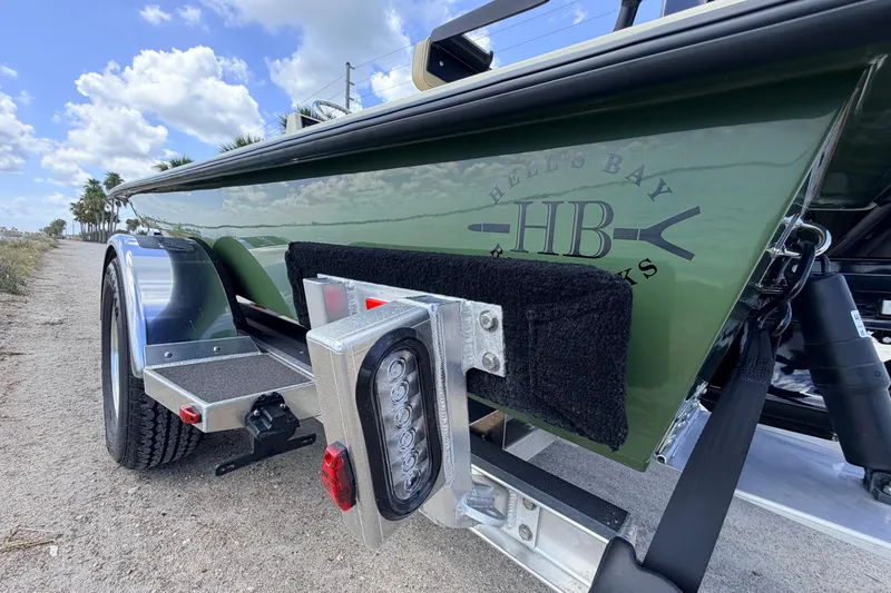 Slide: The Image of 2025 Hell's Bay Professional boat on trailer, showcasing sleek design and branding. - 16