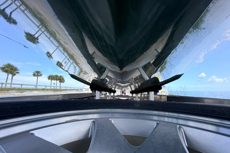 Slide: The Image of Underneath view of a 2025 Hell's Bay Professional boat on a trailer by the sea. - 12