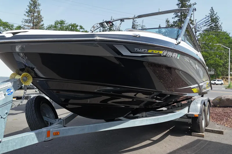 Slide: The Image of 2016 Yamaha Boats 212X on trailer, sleek black design, parked outdoors. - 3