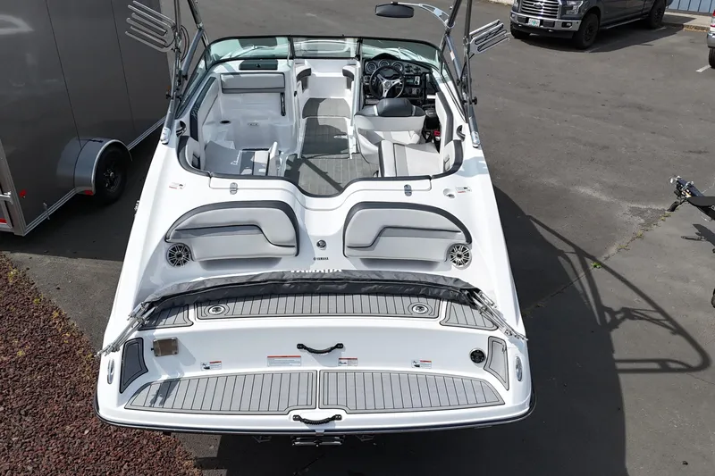 Slide: The Image of 2016 Yamaha Boats 212X, white interior, parked on pavement, showcasing seating and dashboard. - 13
