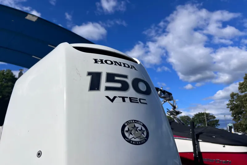 Slide: The Image of Honda 150 VTEC outboard motor on a 2021 Starcraft SVX 211 OB boat under blue sky. - 3