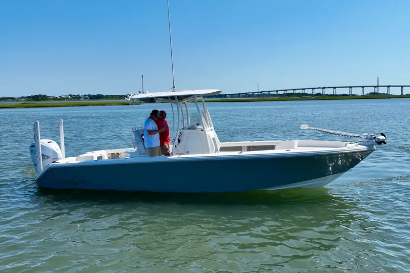 Slide: The Image of A white boat with two people on board is cruising on calm water. A bridge is visible in the background. - 7