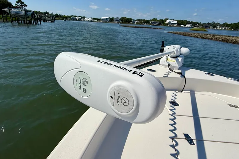 Slide: The Image of A boat with a Minn Kota trolling motor on calm water in a coastal area. - 23