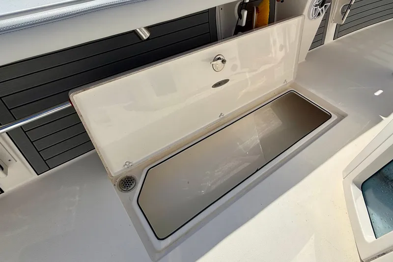 Slide: The Image of An open storage compartment on a boat with gray panels in the background. - 37