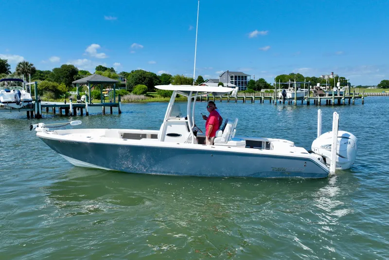 Slide: The Image of A white boat on the water with a person at the helm. Docks and houses are in the background. - 11