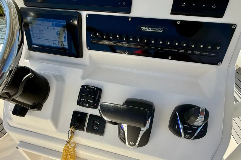 Slide: The Image of The image shows the helm of a 2022 Pathfinder 2700 Open boat with various controls. - 42